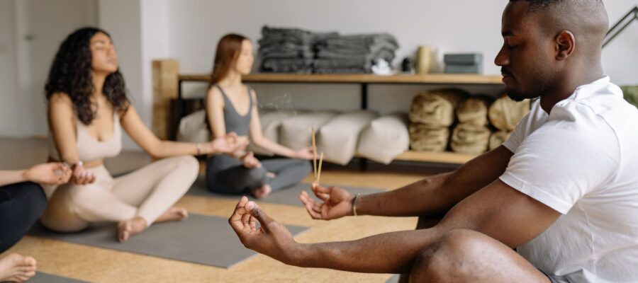 yoga teacher meditating with group