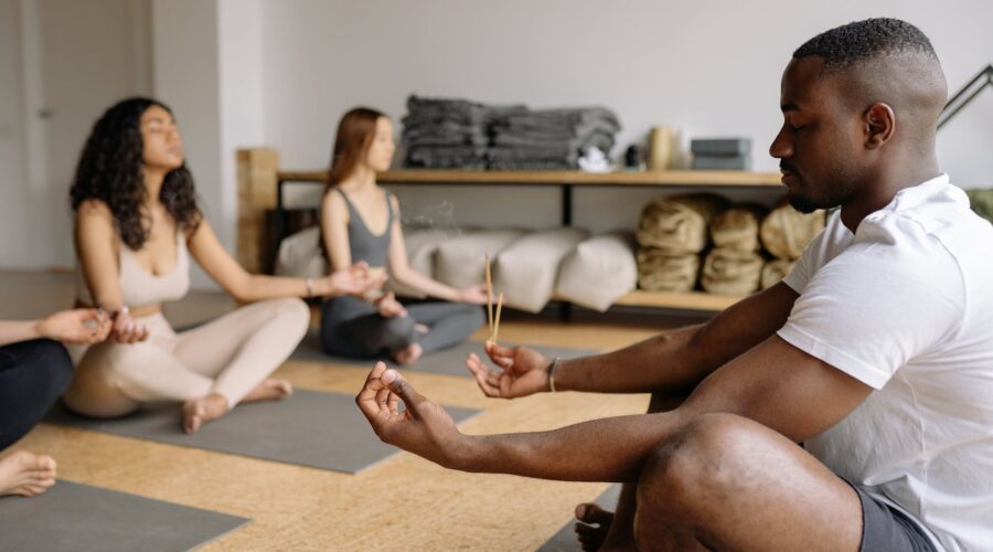 yoga teacher meditating with group